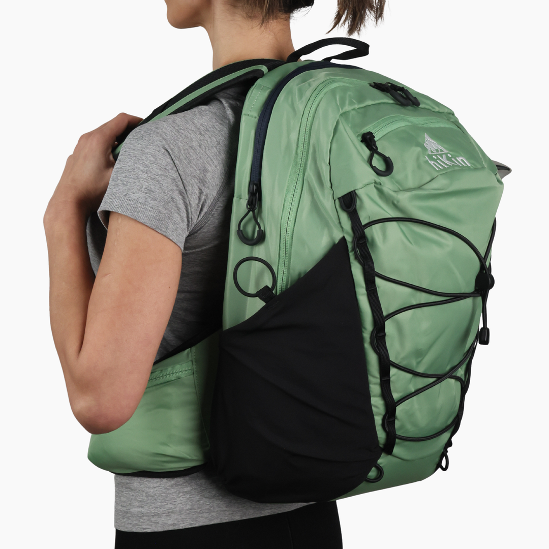 Back view of a hiker wearing the sage green Canyon Elite 25 hiking pack