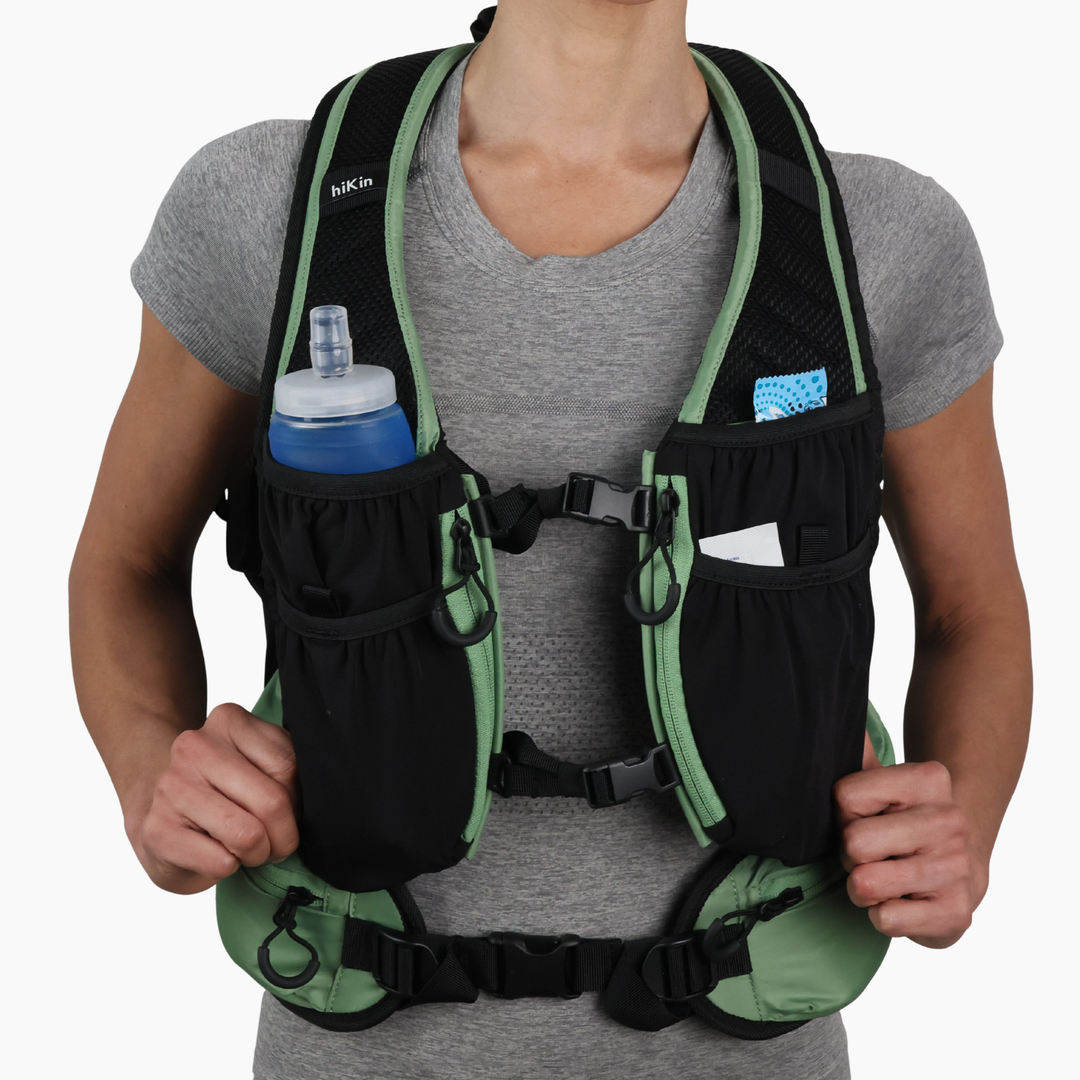Front view of a hiker wearing the sage green Canyon Elite 25 backpack
