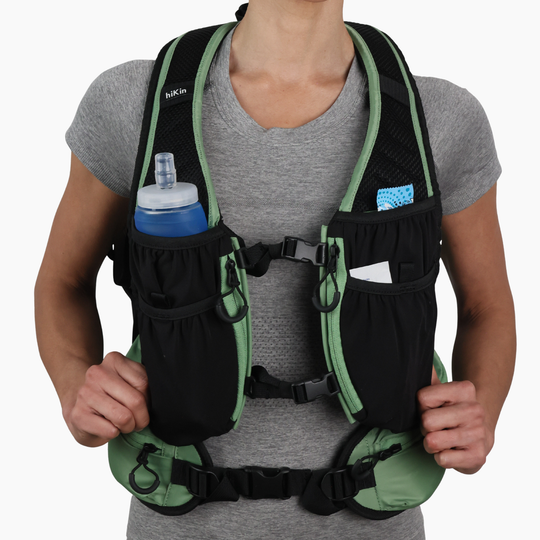 Front view of a hiker wearing the sage green Canyon Elite 25 backpack