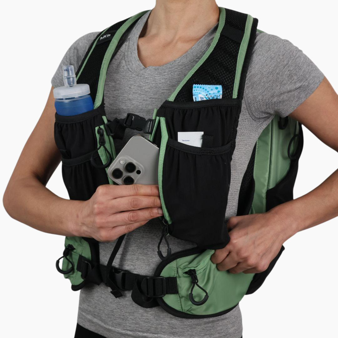 Sage green Canyon Elite 25 hiking pack with water bottle, phone, and essentials stored in the front pockets
